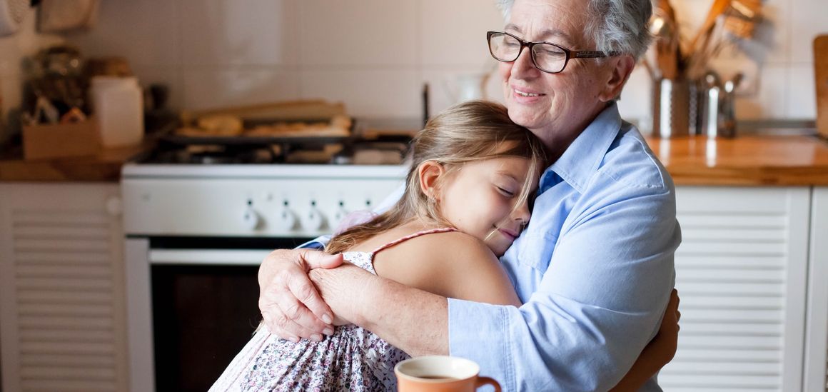Una abuela abraza a su nieta en la cocina