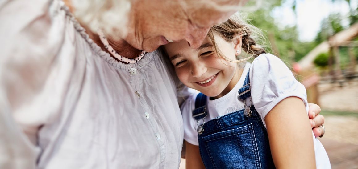 Una abuela y su nieta sonríen, frente con frente
