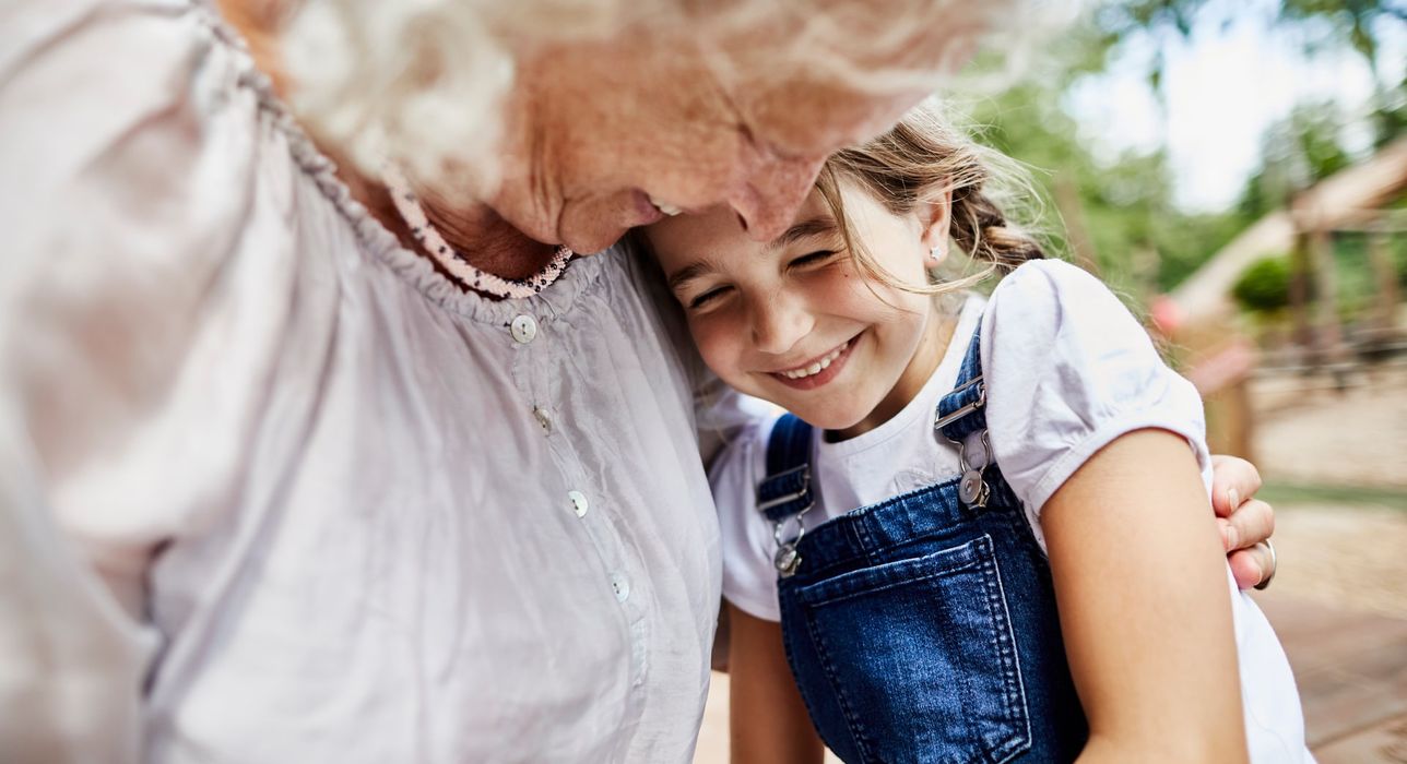 Una abuela y su nieta sonríen, frente con frente