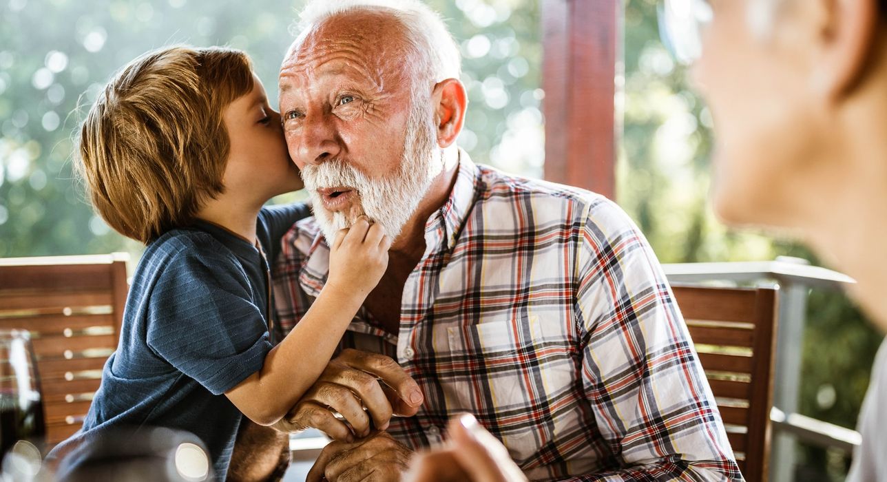 Un niño besa a su abuelo en la mejilla